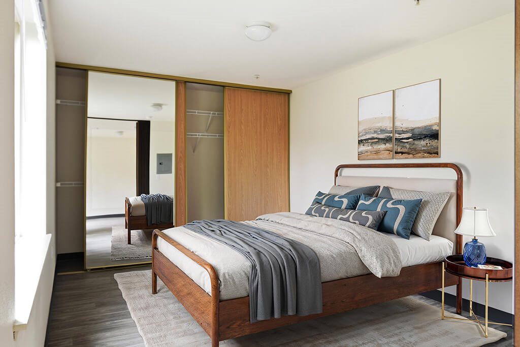 A bedroom with a bed, a nightstand, and a chair.